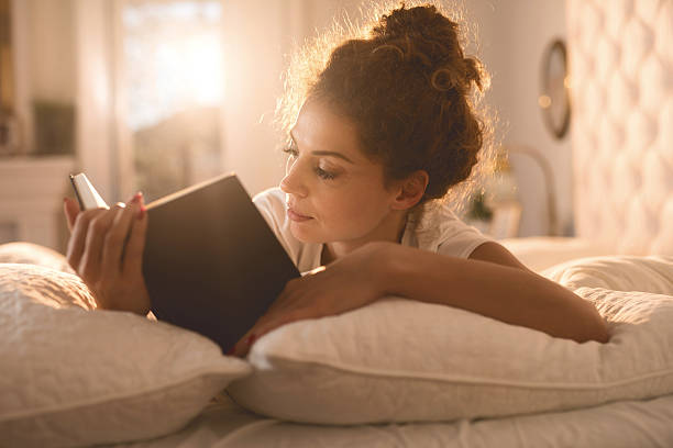 istock Relaxed woman reading a book in her bed. 507184020