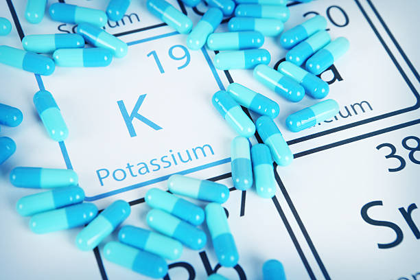 Potassium - Mineral Supplement on Periodic Table Potassium with capsules or pills on the periodic table (Periodic table made by me) Stock image representing mineral supplementation. vitamins and minerals chart stock pictures, royalty-free photos & images