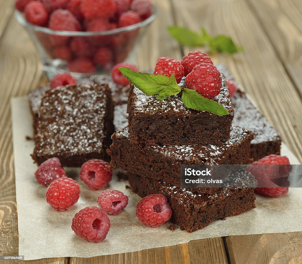 Chocolate brownies with raspberries Chocolate brownies with raspberries on brown background Appetizer Stock Photo