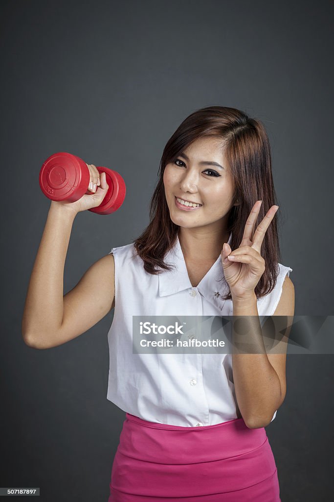 Feliz Menina asiática segurando um Haltere Mostrar vicrtory sinal - Royalty-free Adulto Foto de stock