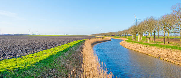 istock Canal through a sunny landscape in winter 507204558