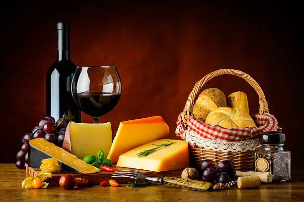 Food in still life with cheese, red wine and bun