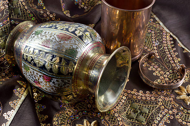 Indian ethnic still life with golden vase, copper goblet and bracelet