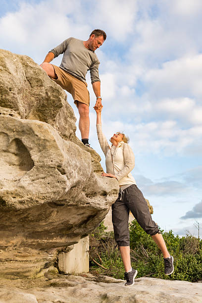 istock Active Fit Mature Couple Helping Each Other Hiking 507209934