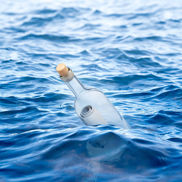 istock Bottle with a letter swims in the sea 507210561