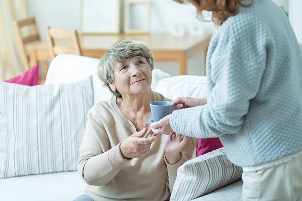 istock Caregiver giving elder woman coffee 507210968