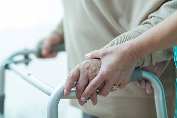 Close-up of woman using walker Close-up of woman using walker assisted by carer nurse smock stock pictures, royalty-free photos & images