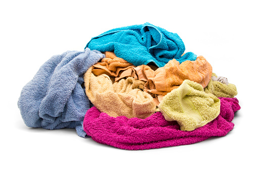 Pile of wet dirty towels isolated on white.