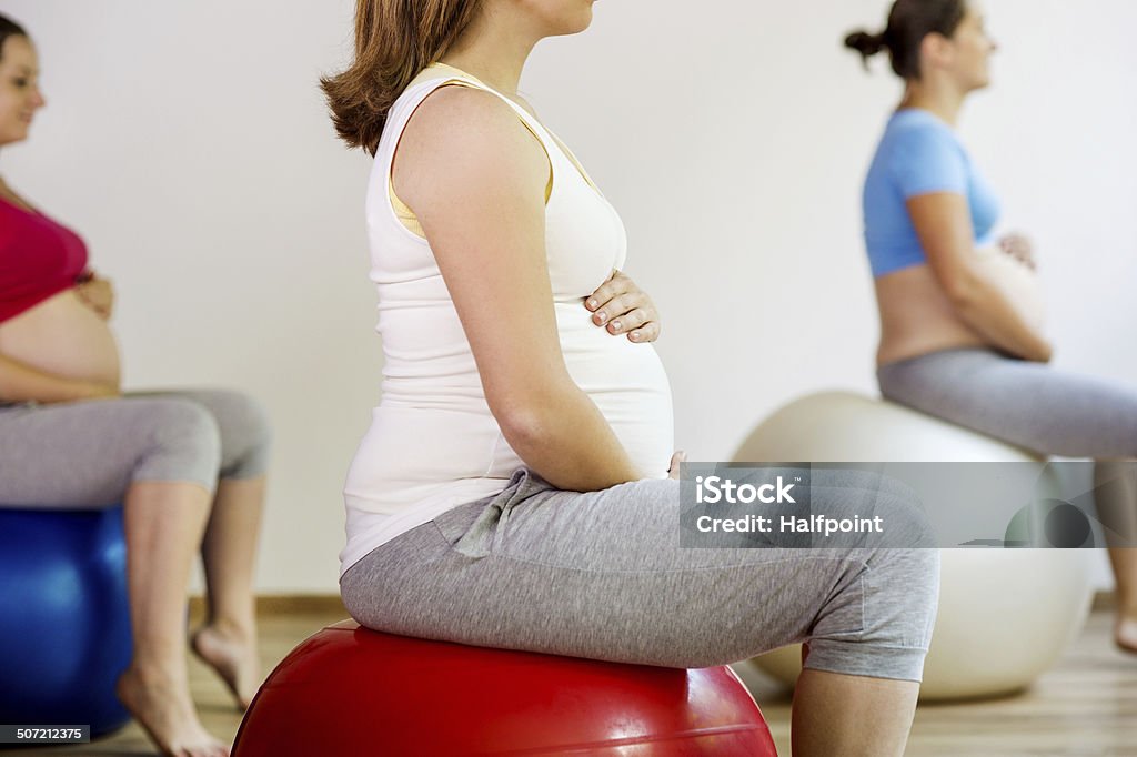 Pregnant women exercising Young pregnant women doing exercise using a fitness ball Pilates Stock Photo