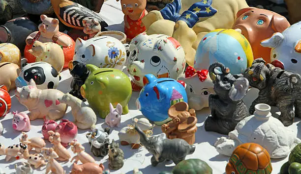 many antique piggy banks for sale at flea market stall