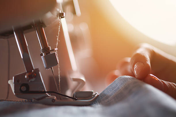 sarto al lavoro sulla macchina per cucire - industria della moda foto e immagini stock