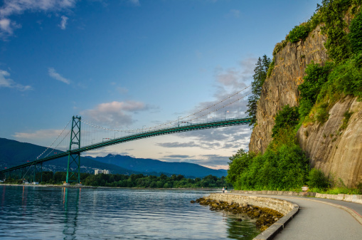 Lions Gate Bridge and Seawall of Vancouver at Sunset with people in motion.