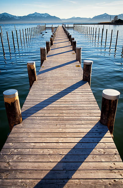 old wooden jetty old wooden jetty at the chiemsee lake in bavaria bollard pier water lake stock pictures, royalty-free photos & images