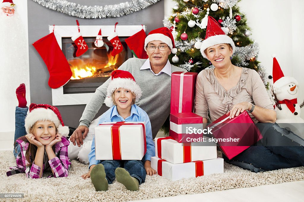 Grandparents and grandchildren on New Year's Eve. Grandparents celebrating Christmas holiday with their grandchildren and looking at the camera. Active Seniors Stock Photo