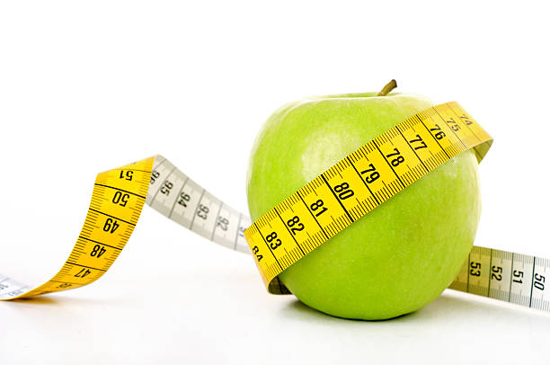 istock Diet concept, green apple wrapped with measuring tape 507214608