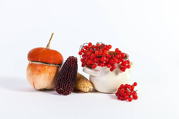 Autumn food concept, pumpkin soup in a glass bowl decorated with an orange knitted sweater and a sprig with yellow autumn leaves