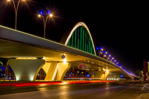 A luminous bridge in Riyadh city at midnight