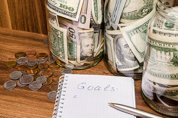 istock New years resolutions with dollar in glass jar, coins 507216282