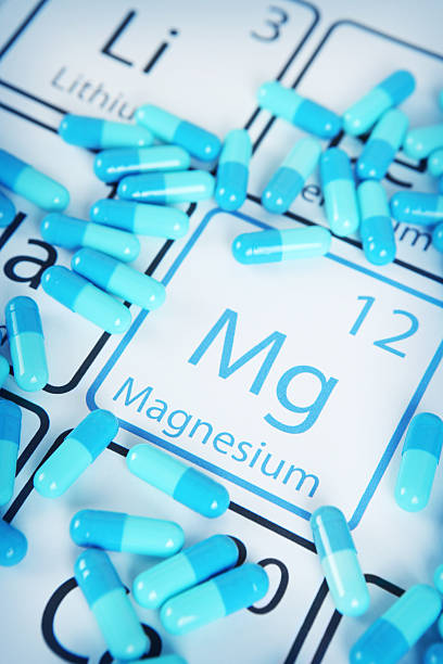 Magnesium - Mineral Supplement on Periodic Table Magnesium with capsules or pills on the periodic table (Periodic table made by me) Stock image representing mineral supplementation. vitamins and minerals chart stock pictures, royalty-free photos & images