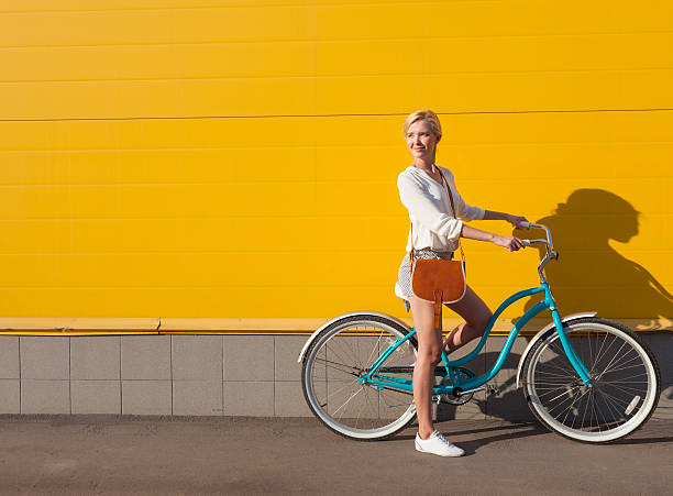 jeune blonde fille sexy, debout près du vélo vintage - women spring sensuality fashion model photos et images de collection