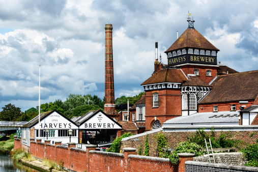 Lewes, England - July 28, 2014: Harveys Brewery in Lewes, East Sussex, England. Old factory buildings. One background person under bridge.