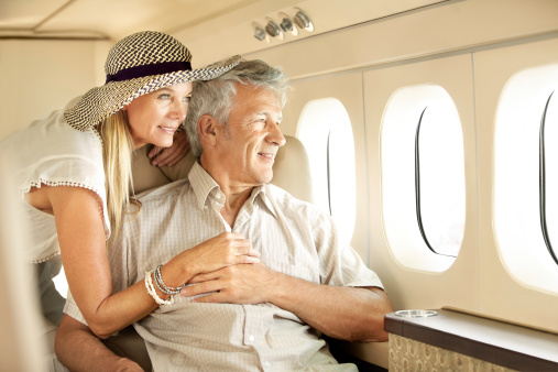 Smiling senior couple on an airplane looking out the window
