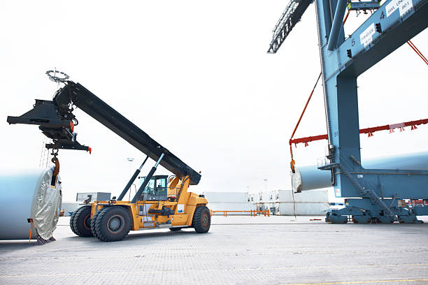 Careful handling is the key to this industry A loader in a vehicle handling cargo in an industrial area shipping heavy equipment machinery stock pictures, royalty-free photos & images
