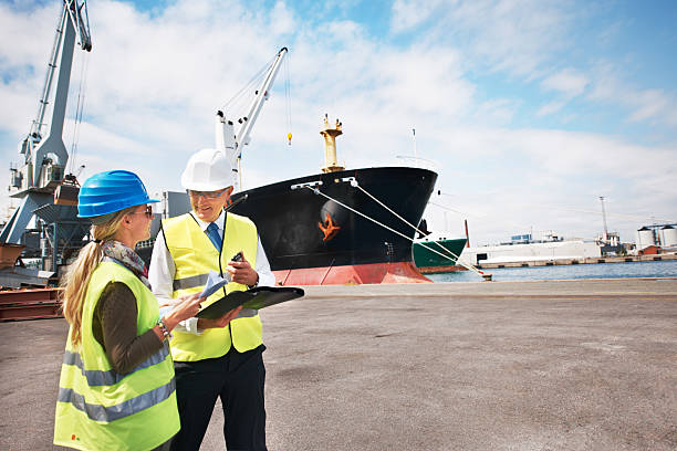 Sound management ensures fair customs trade Two dock workers holding paperwork while standing in the shipyard customs official photos stock pictures, royalty-free photos & images