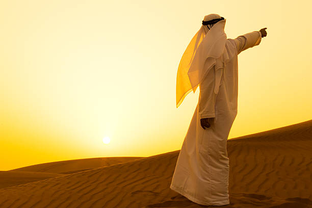 istock Arab pointing at a direction in the dunes of Dubai 507246652