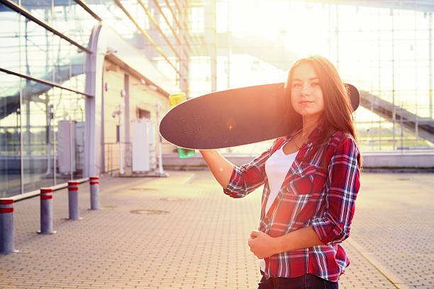 istock Beautiful young woman with a skateboard 507247520