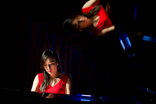 istock beautiful woman playing piano 507251520