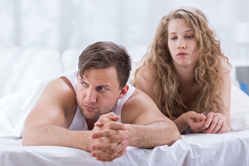 Couple is lying in bed and sad after having argument