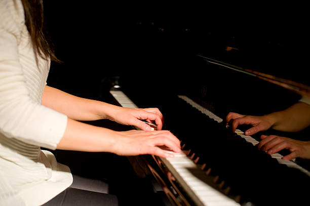 istock beautiful woman playing piano 507253236