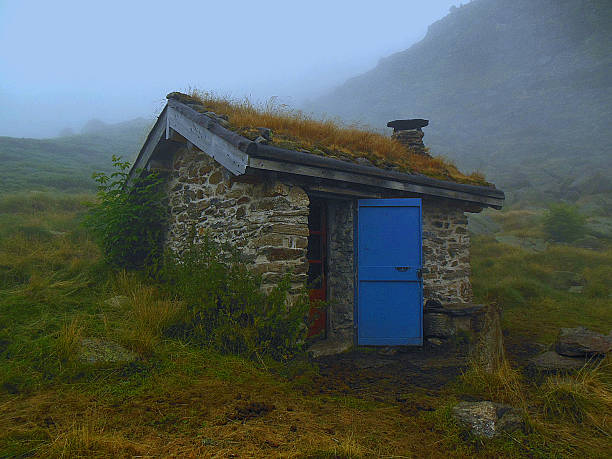A cottage revealing itself through the fog in the pyrenees.