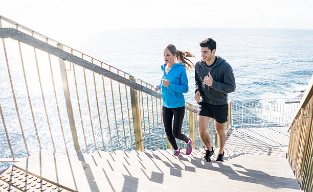 pareja corriendo juntos al aire libre - staircase running moving up jogging fotografías e imágenes de stock