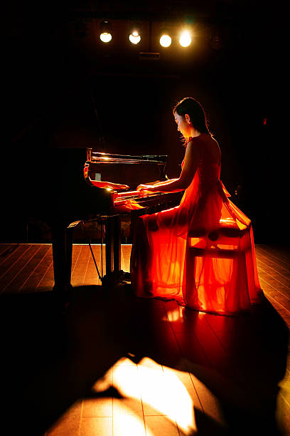 istock beautiful woman playing piano 507257798