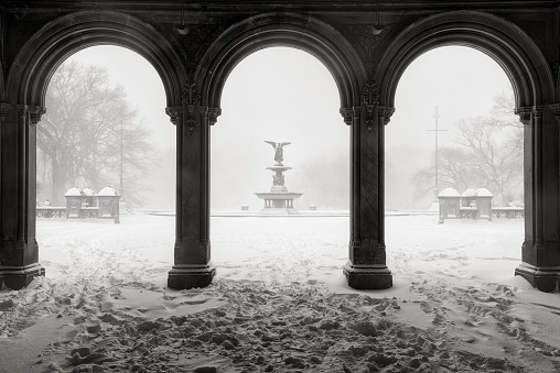 Early morning Black & White view of the Bethesda Fountain from the Bethesda Terrace Arcade during a freezing cold winter snowstorm. Wintertime in Central Park, Manhattan, new York City