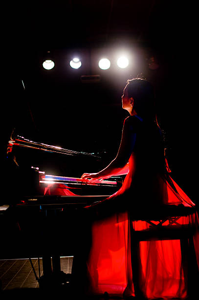 istock beautiful woman playing piano 507258388