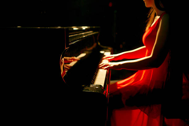 istock beautiful woman playing piano 507260284