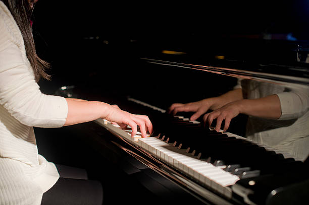 istock beautiful woman playing piano 507260480