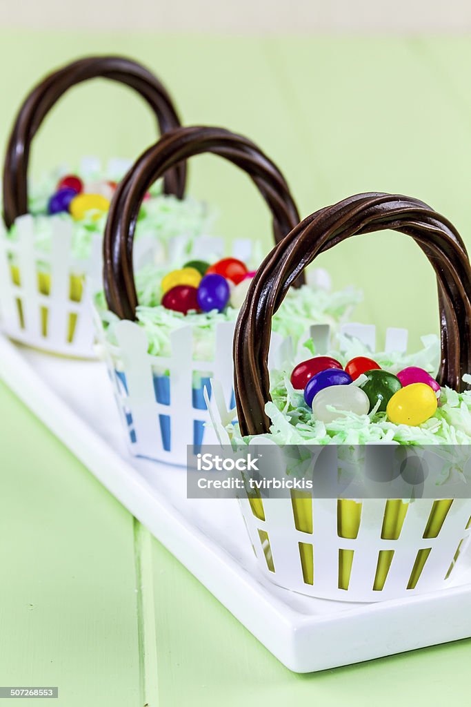 Easter Basket Cupcakes Row of Easter basket cupcakes with colorful jelly beans and coconut grass April Stock Photo