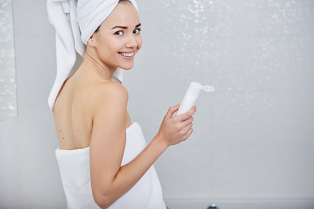 Beautiful Young Woman applying facial moisturizing cream.Skincare concept Beautiful Woman applying facial moisturizing cream.Skincare concept girls bath stock pictures, royalty-free photos & images