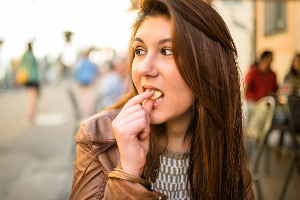 istock woman biting a snack at the cafe 507270893