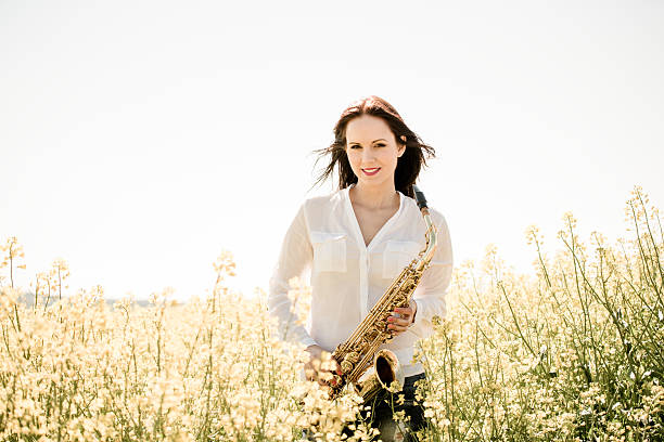 istock Woman with saxophone in rapeseed field 507272220