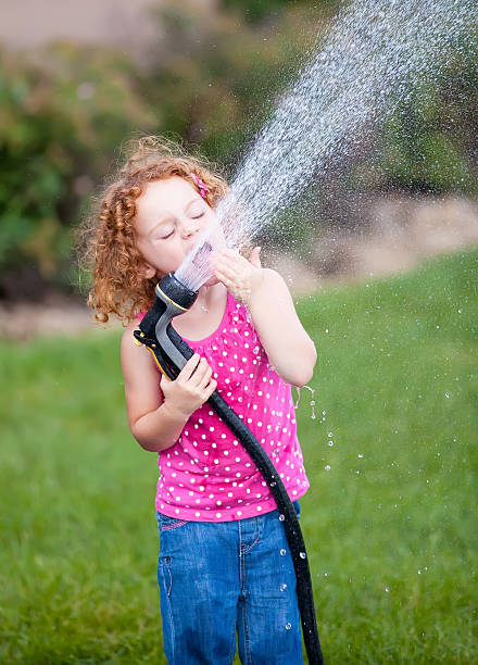 Child Drinking From Garden Hose