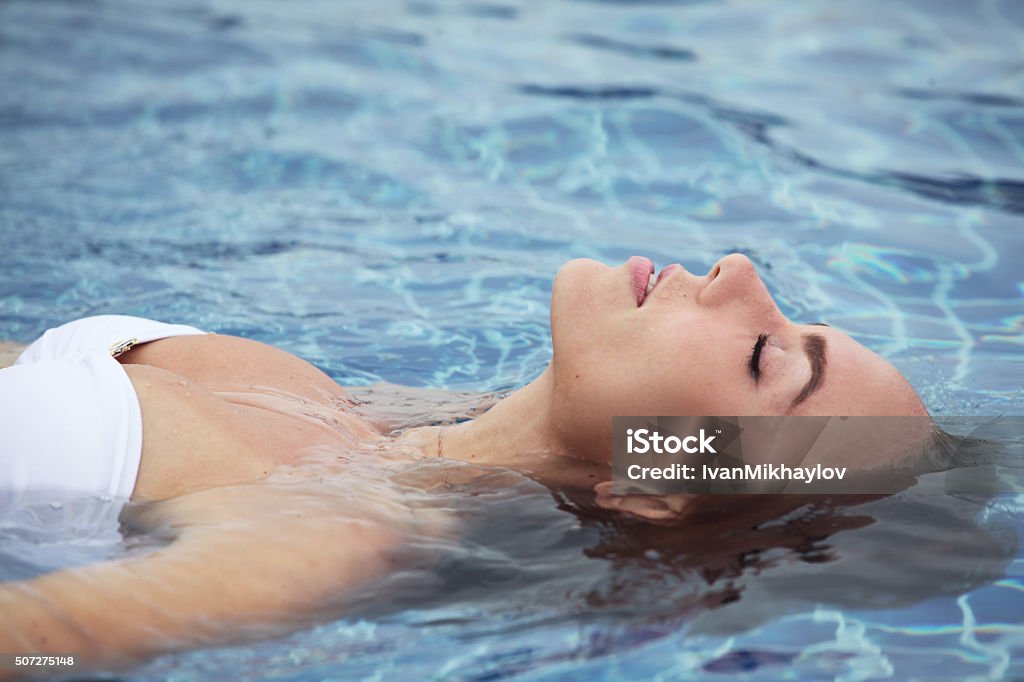 Femme flottant sur la piscine - Photo de Flotter sur l'eau libre de droits