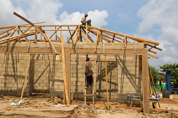 lavoratori costruendo una casa di legno in nigeria, africa - nigerian culture men africa african culture foto e immagini stock