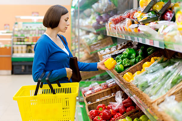 istock woman in a shop considering vegetables. 507276438