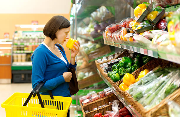 istock woman in a shop considering vegetables. 507276600