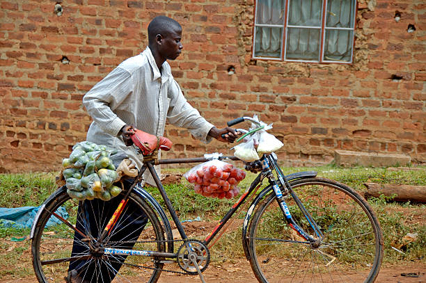 Kampala, Uganda-10 April 2007: Man with bike. He is carrying fruit and vegetables to bring home.